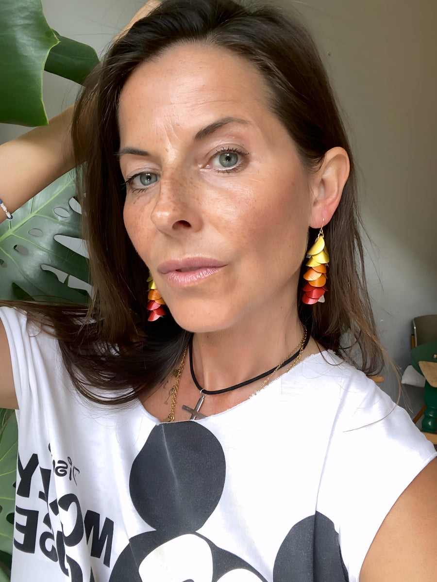 model wears sunset, sunrise themed gold-orange-red earrings made from upcycled nespresso pod aluminium