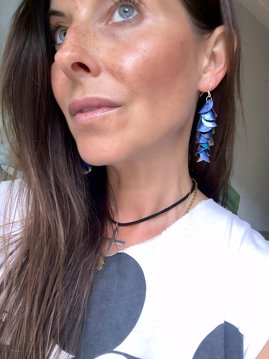 model wears blue cascade earrings made from upcycled nespresso pod aluminium
