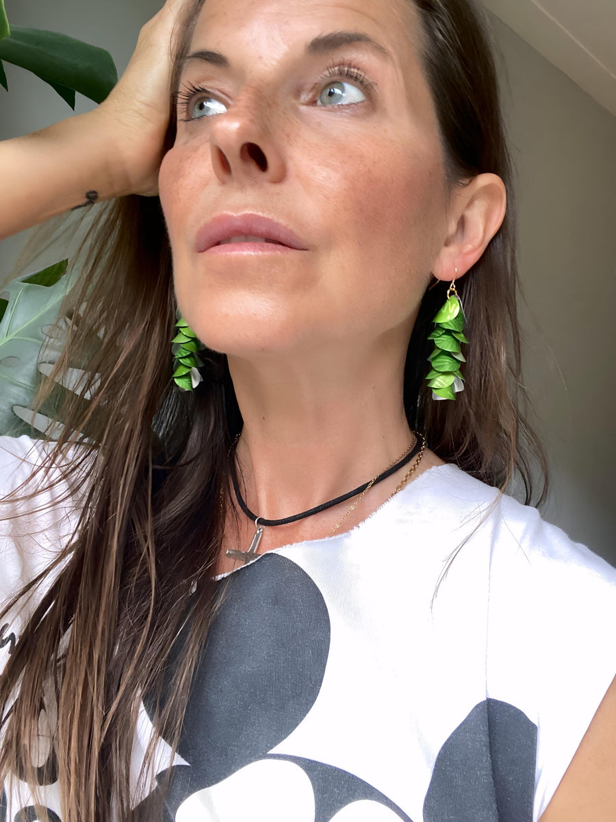 model wears bright lime green cascade earrings made from upcycled nespresso pod aluminium