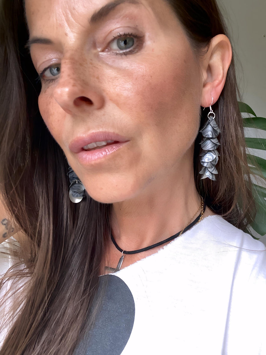 model wears silver coloured cascade earrings made from upcycled nespresso pod aluminium