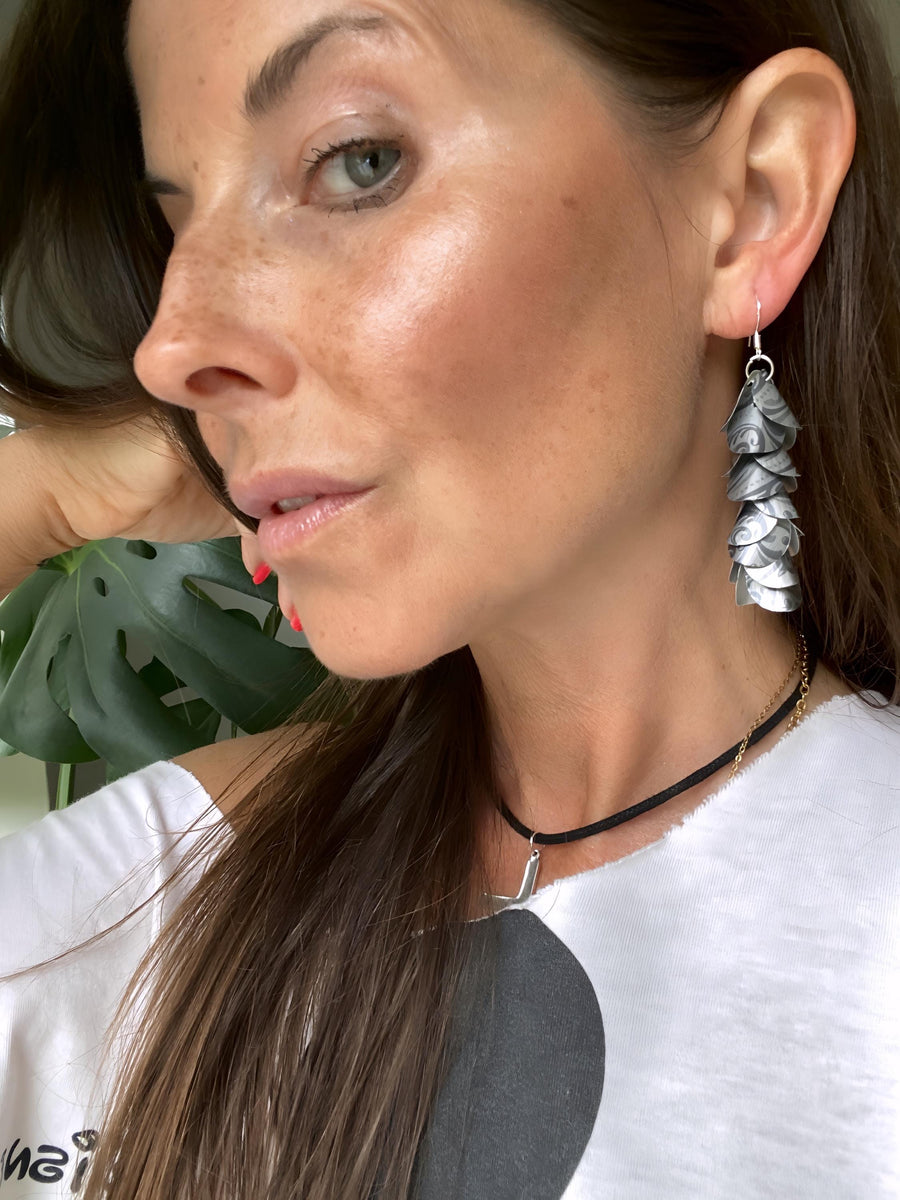 model wears silver coloured cascade earrings made from upcycled nespresso pod aluminium