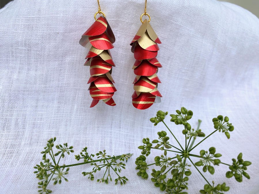 red gold upcycled earrings made from nespresso capsules aluminium on a white linen background and a green flower