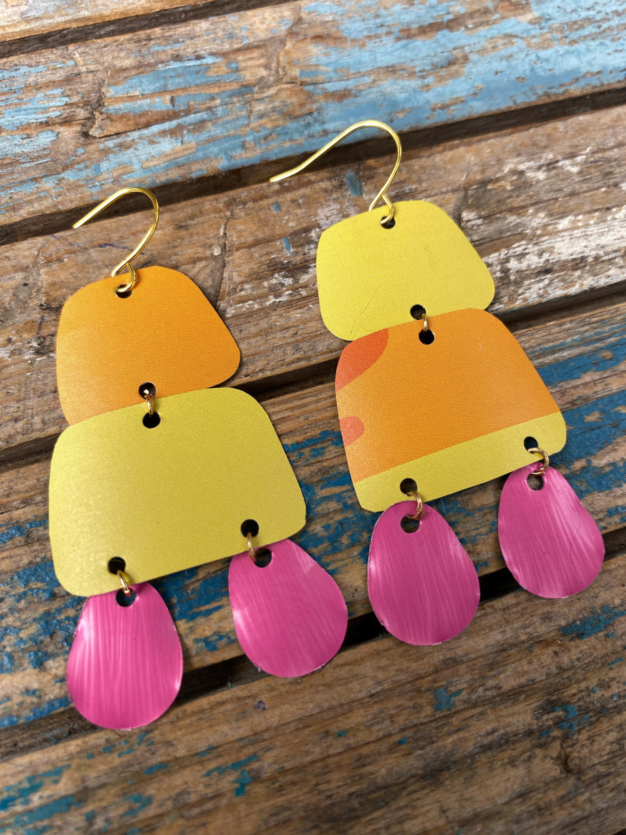pair of orange yellow pink summer earrings made from upcycled beer can and Nespresso capsules on a rustic wooden background
