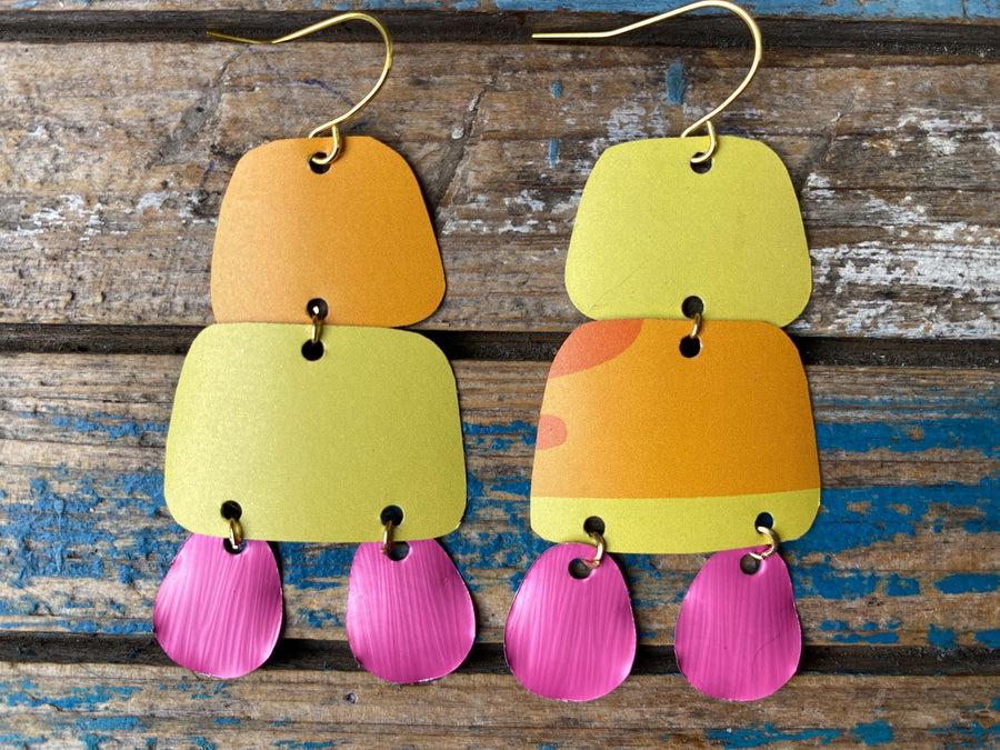 pair of orange yellow pink summer earrings made from upcycled beer can and Nespresso capsules on a rustic wooden background