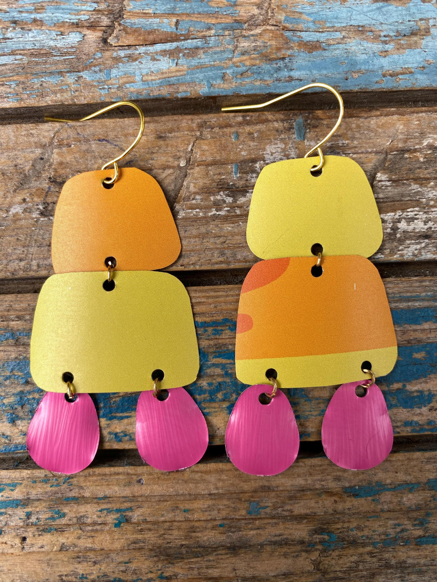 pair of orange yellow pink summer earrings made from upcycled beer can and Nespresso capsules on a rustic wooden background