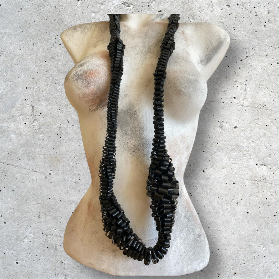 very bold, black scultural necklace made from upcycled bicycle inner tube strips on a mannequin