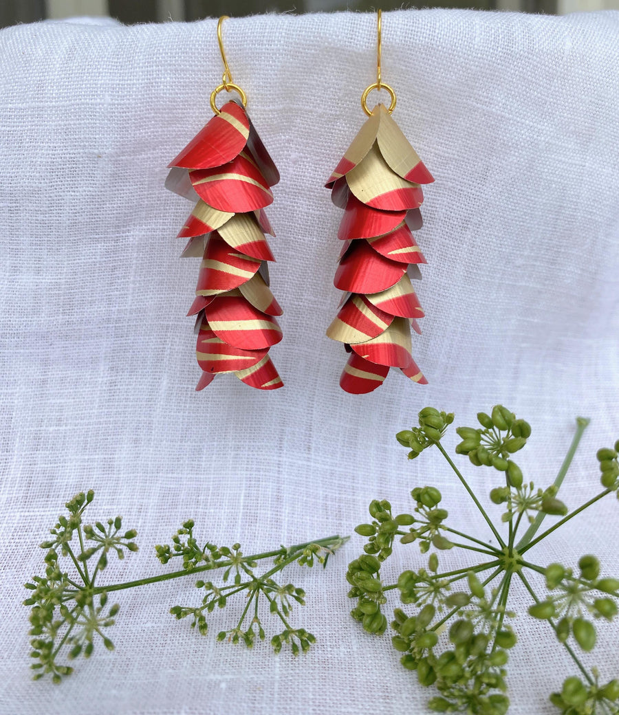 red gold upcycled earrings made from nespresso capsules aluminium on a white linen background and a green flower