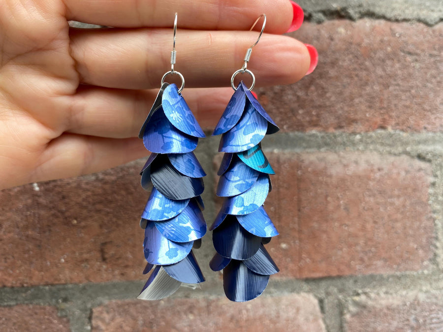 blue cascade earrings made from upcycled nespresso capsule aluminium on brick wall background