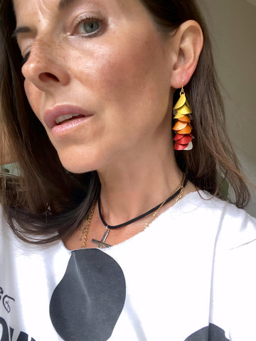model wears sunset, sunrise themed gold-orange-red earrings made from upcycled nespresso pod aluminium