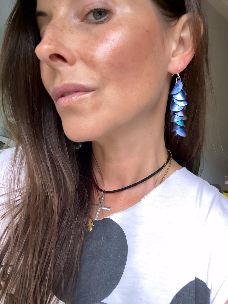 model wears blue cascade earrings made from upcycled nespresso pod aluminium