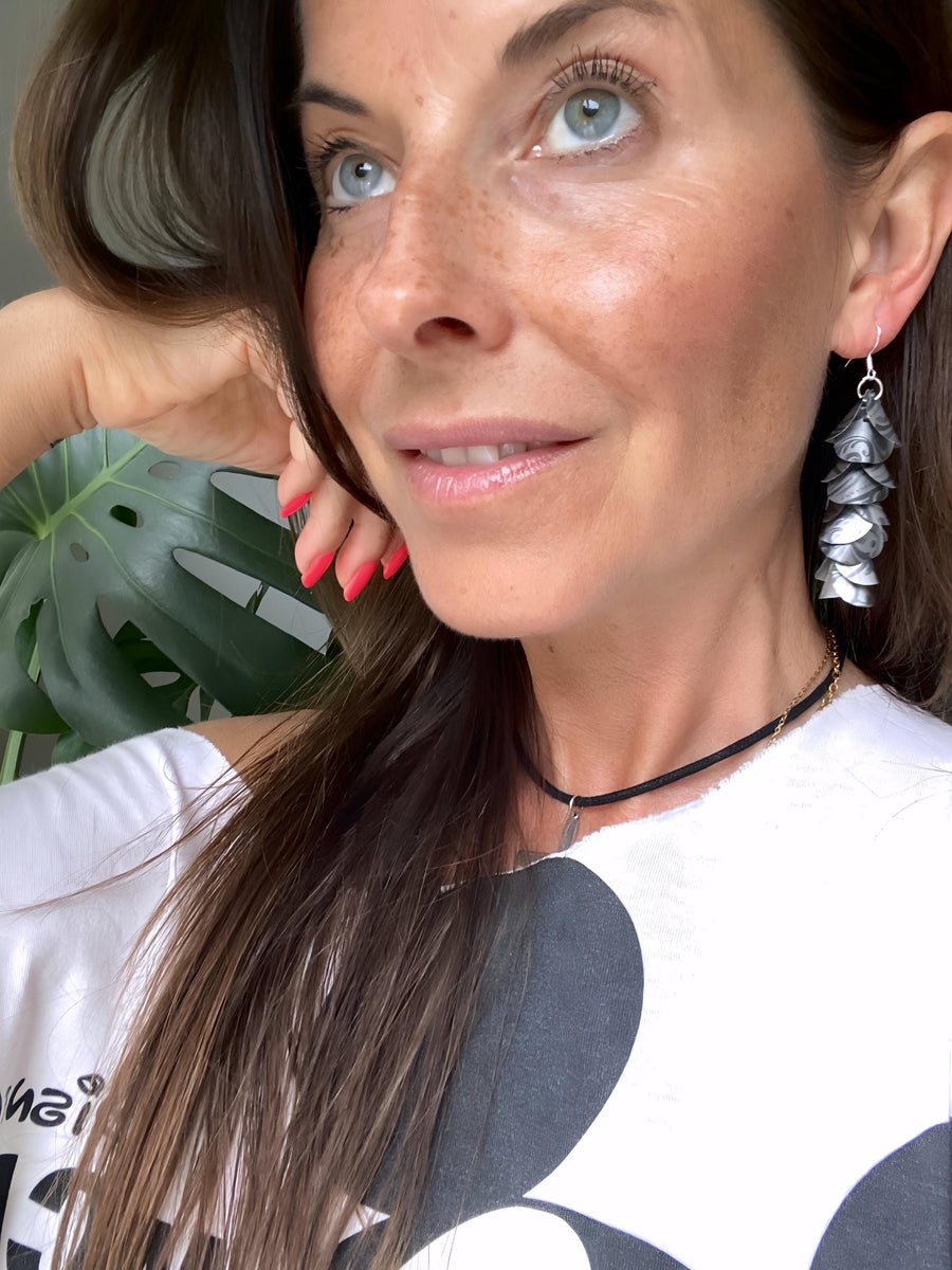 model wears silver coloured cascade earrings made from upcycled nespresso pod aluminium