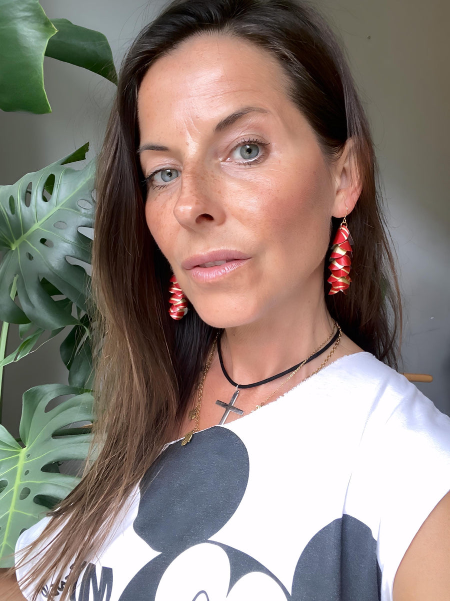 model wears red gold coloured cascade earrings made from upcycled nespresso pod aluminium