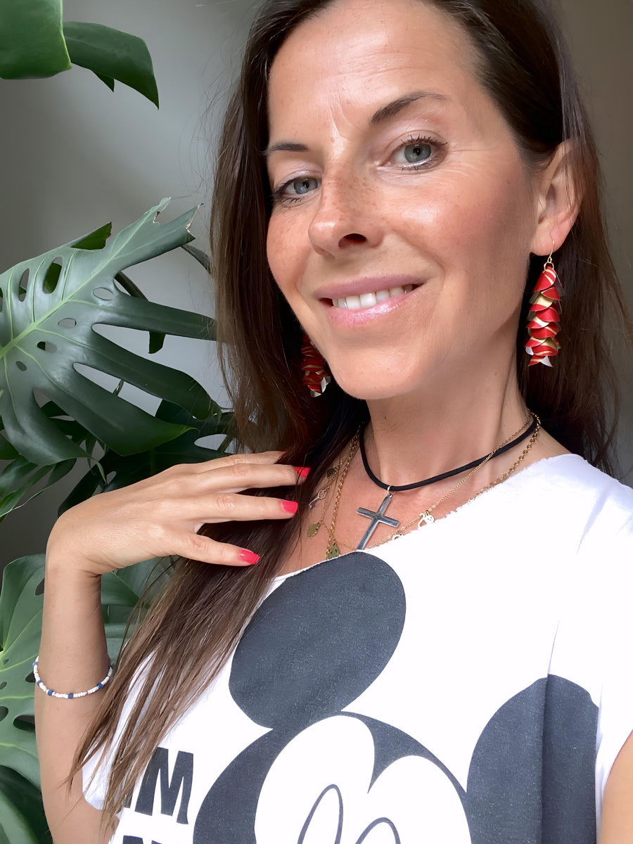 model wears red gold coloured cascade earrings made from upcycled nespresso pod aluminium