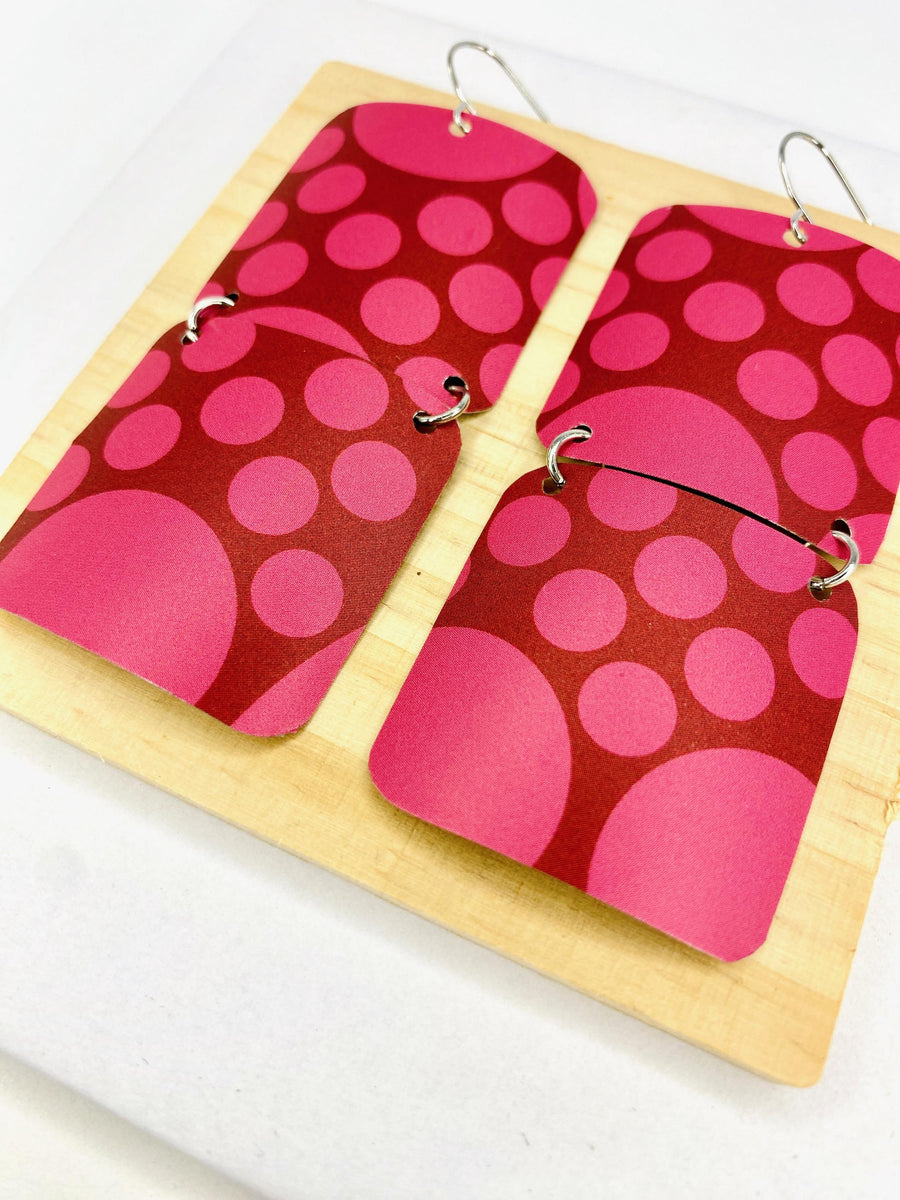 squared cherry coloured, polka dot earrings made from a craft beer can on white background