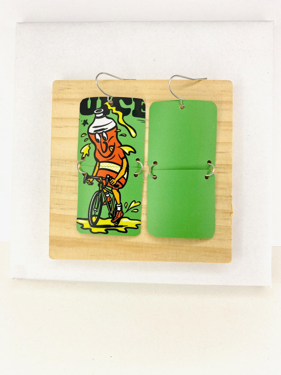 green earrings made from a craft beer can from Other Half Brewery on a wooden and white background