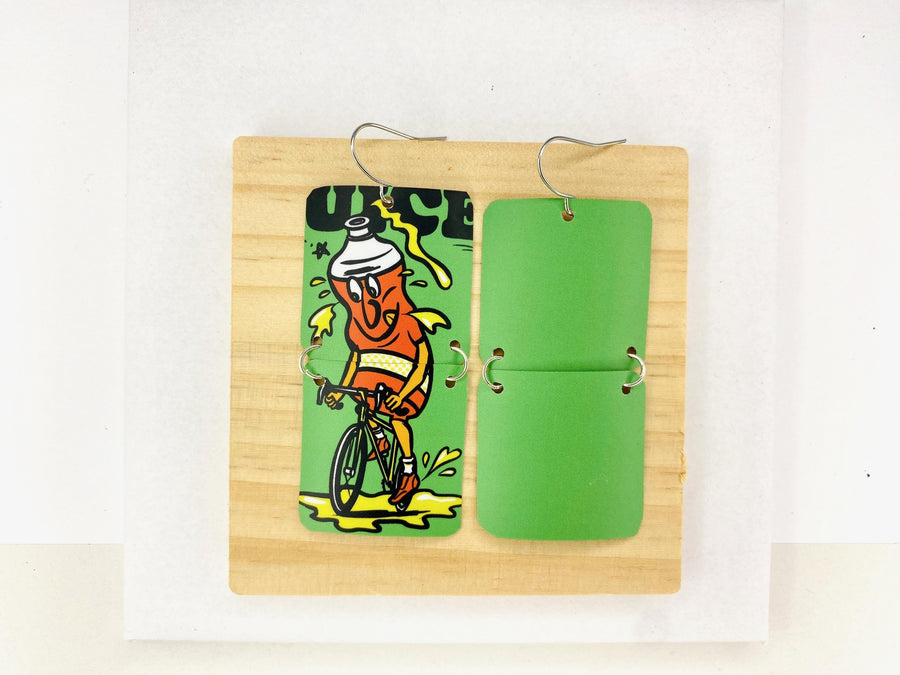 green earrings made from a craft beer can from Other Half Brewery on a wooden and white background