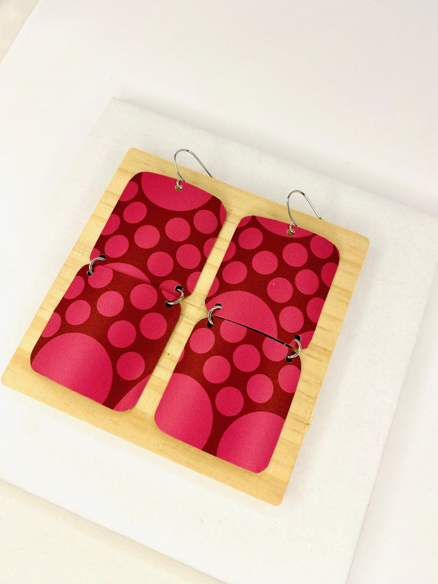 squared cherry coloured, polka dot earrings made from a craft beer can on white background