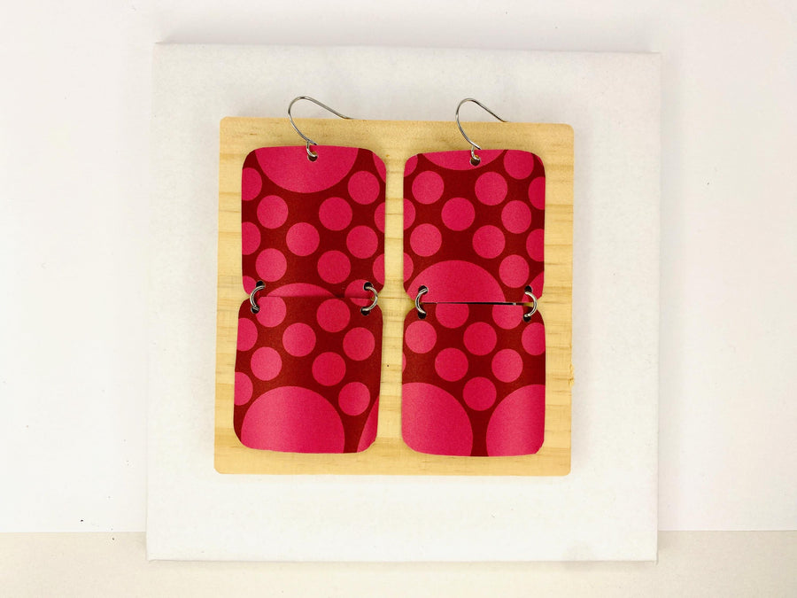 squared cherry coloured, polka dot earrings made from a craft beer can on white background