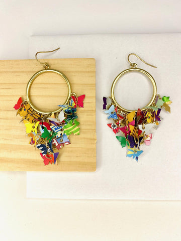 golden hoop earrings with butterflies made from upcycled beer cans and soda cans on a white and wooden background