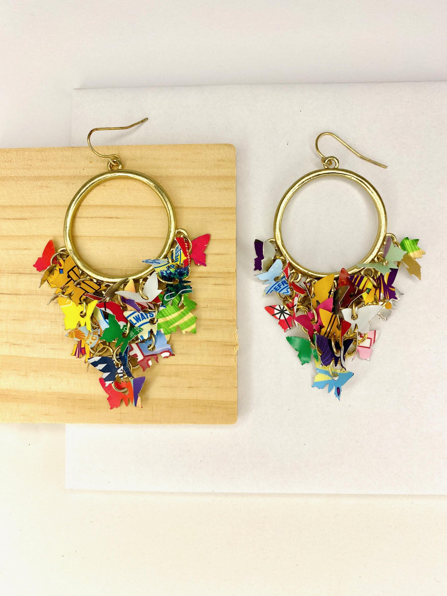 golden hoop earrings with butterflies made from upcycled beer cans and soda cans on a white and wooden background