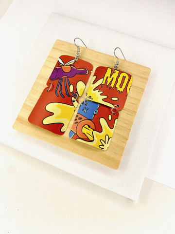 comic, graffiti style earrings made from an upcycled craft beer can in orange, yellow colours, on a wooden and white background