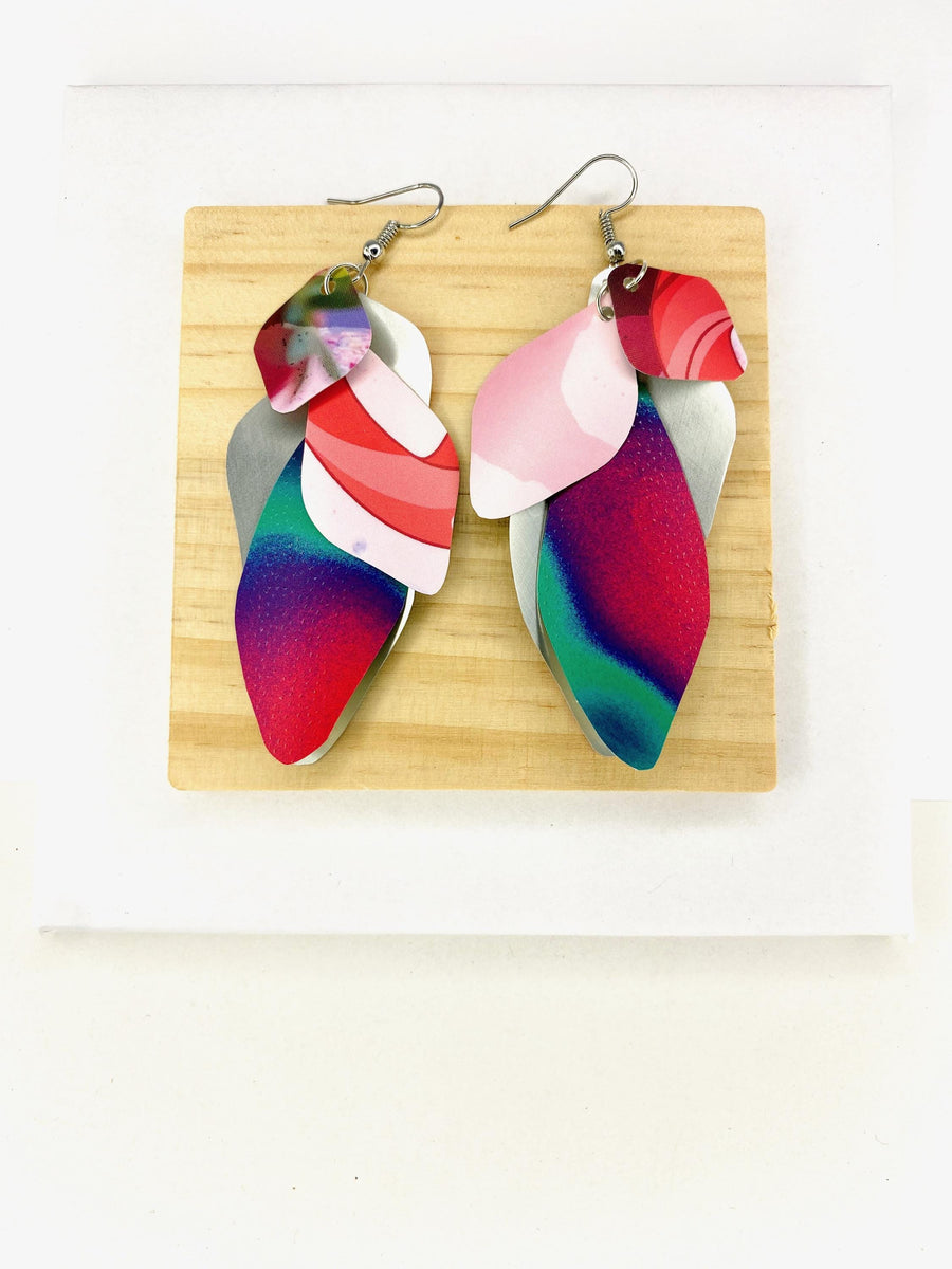 Pink purple green cascade earrings made from upcycled craft beer cans by Laura Zabo on a wooden and white background