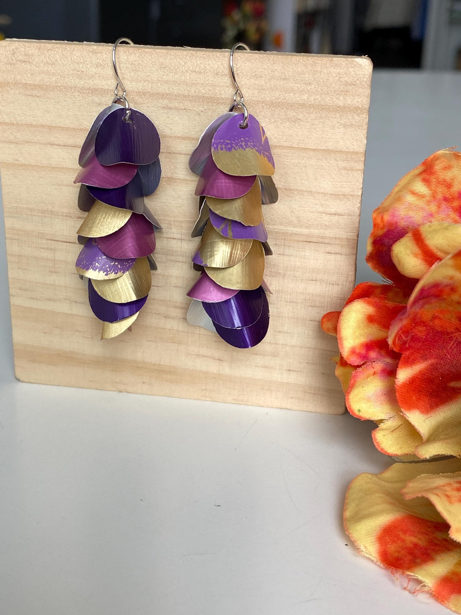gold purple cascade earrings made from upcycled nespresso pods by Laura zabo on a wooden background and a flower