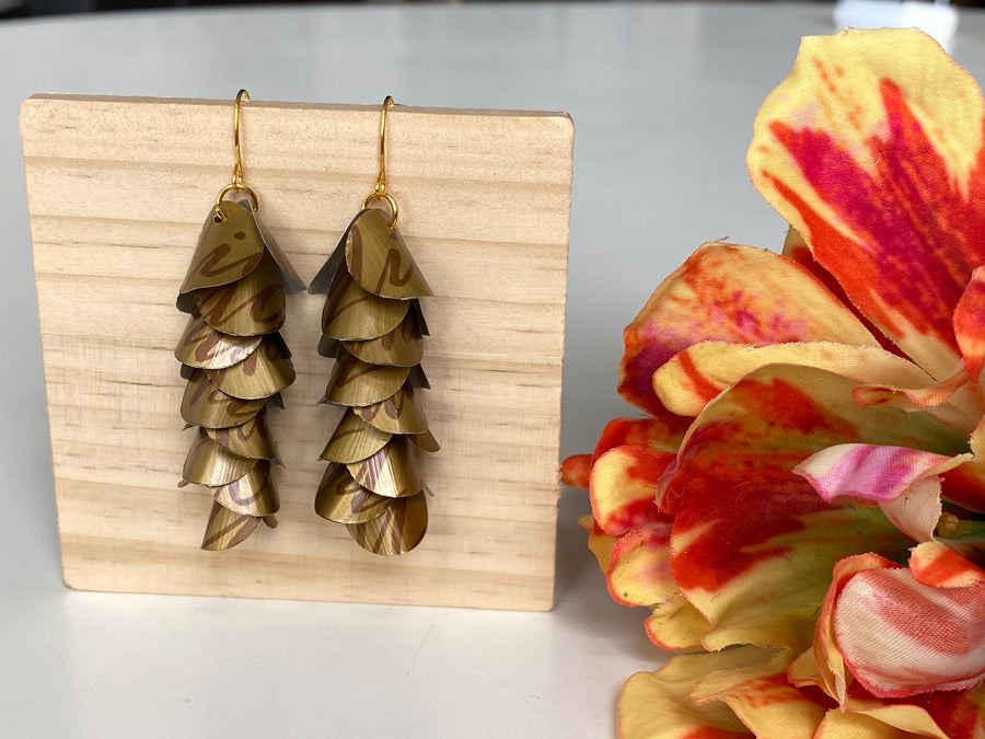 dark gold cascade earrings made from upcycled nespresso coffee pods, Nicaragua capsules by laura zabo, on a wooden background and flower decoration