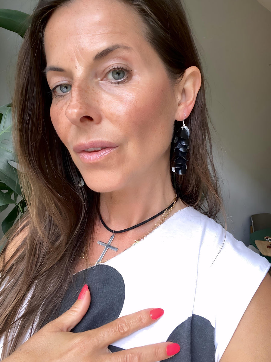 model wears black cascade earrings made from upcycled coffee pods by laura zabo