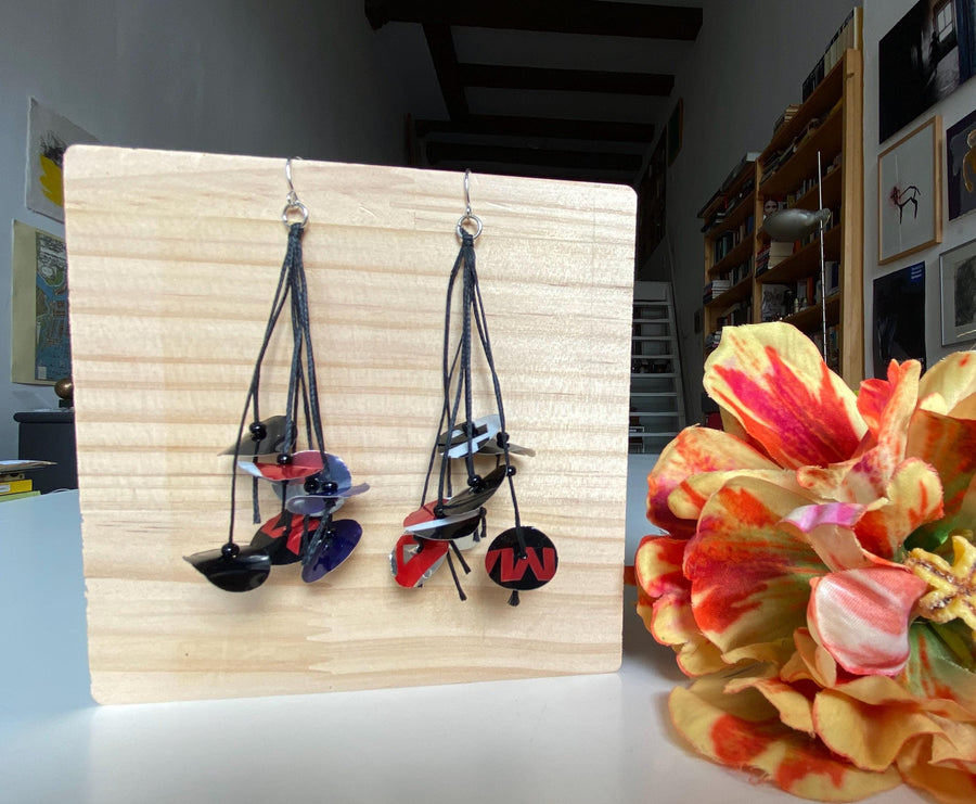black blue red earrings on waxed cotton made from upcycled pepsi cans on a wooden background and flower decoration