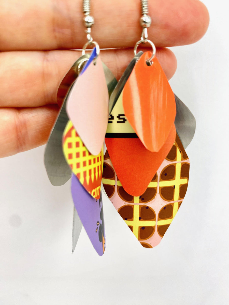 Laura Zabo, colourful , boho , bright cascade earrings made from upcycled craft beer cans hanging in hand
