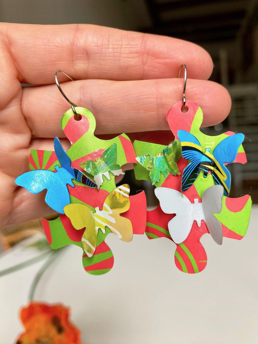 multicoloured, joyful puzzle earrings with butterflies made from craft beer cans by laura zabo hang in hand