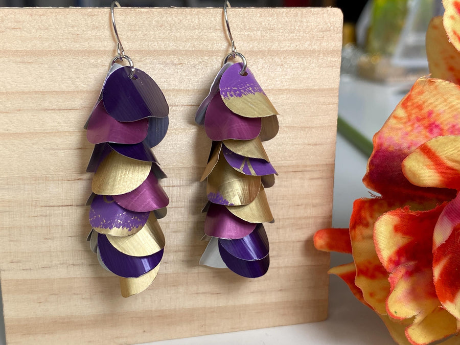 gold purple cascade earrings made from upcycled nespresso pods by Laura zabo on a wooden background and a flower