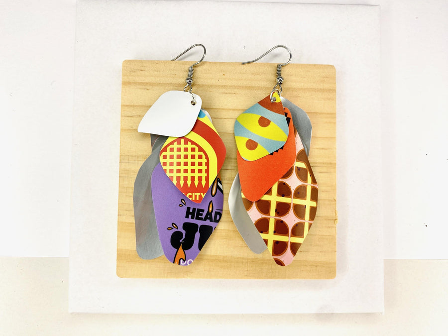 Laura Zabo, colourful , boho , bright cascade earrings made from upcycled craft beer cans on a wooden and white background