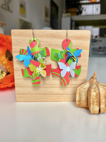 multicoloured, joyful puzzle earrings with butterflies made from craft beer cans by laura zabo on a wooden backround
