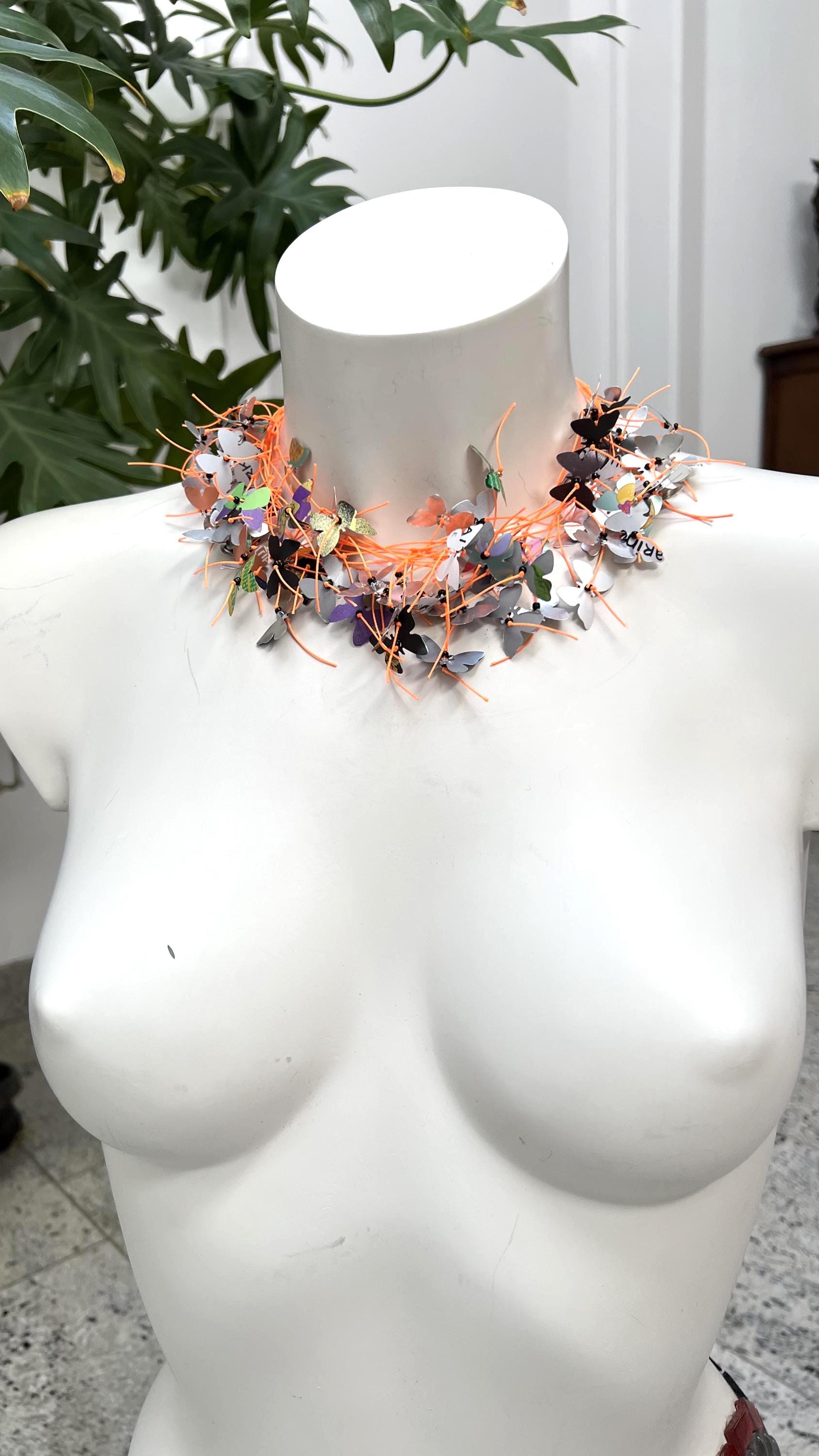 orange cord and aluminium butterfly necklace, the butterflies are cut from upcycled soda and beer cans on a white mannequin
