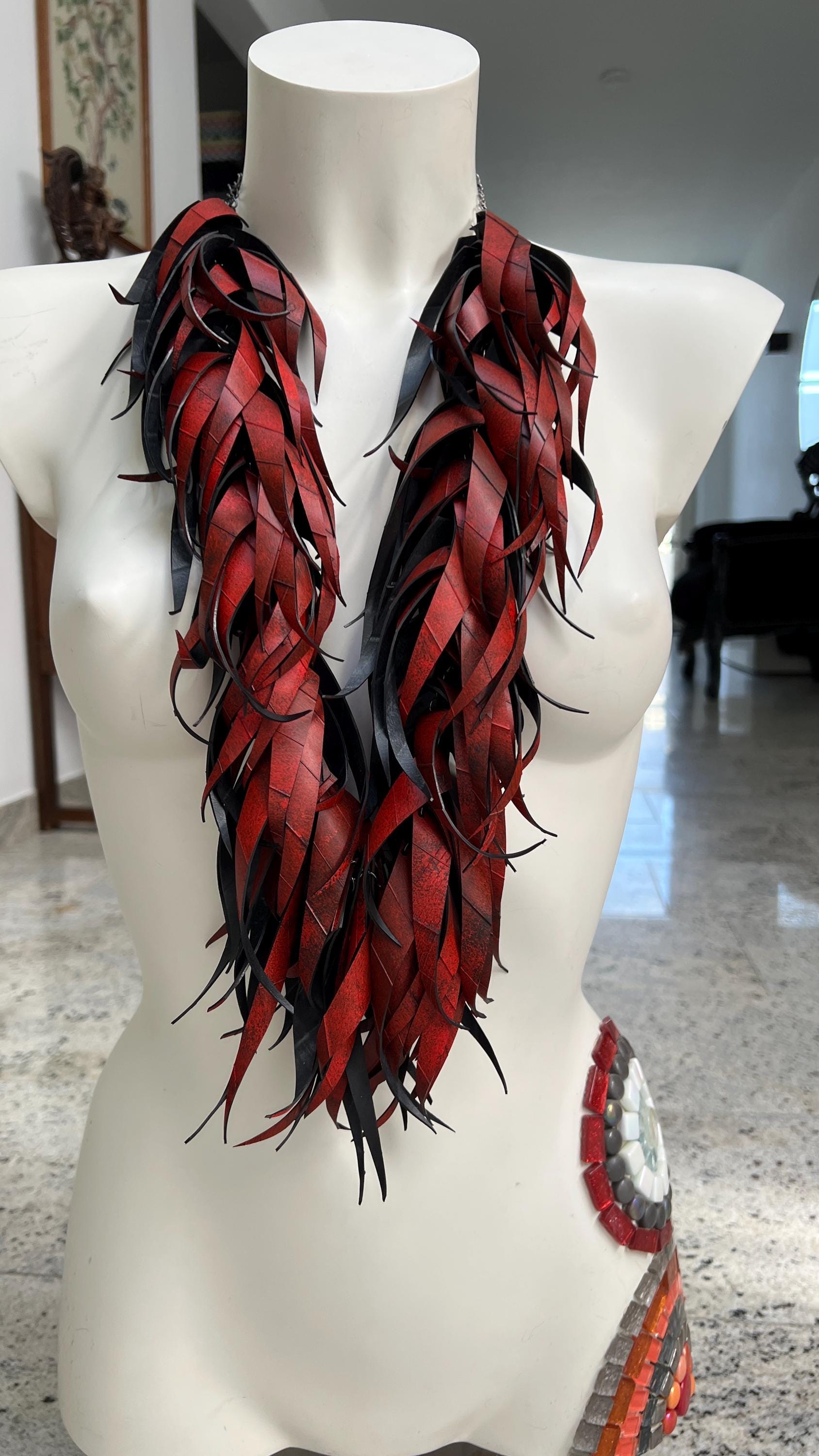 large, long red curly tassel neckace made from upcycled bicycle inner tube rubber on a white mannequin