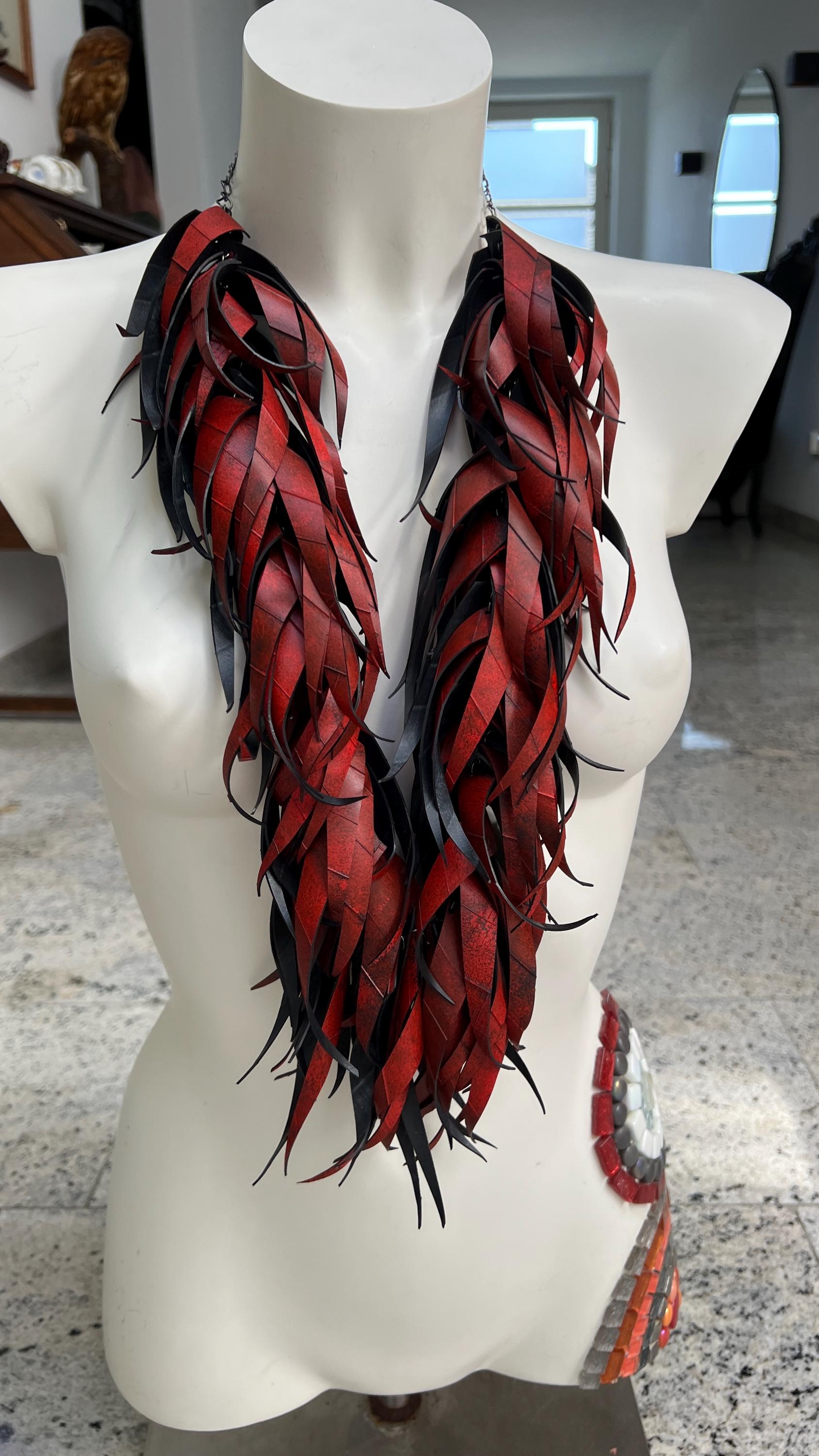 large, long red curly tassel neckace made from upcycled bicycle inner tube rubber on a white mannequin