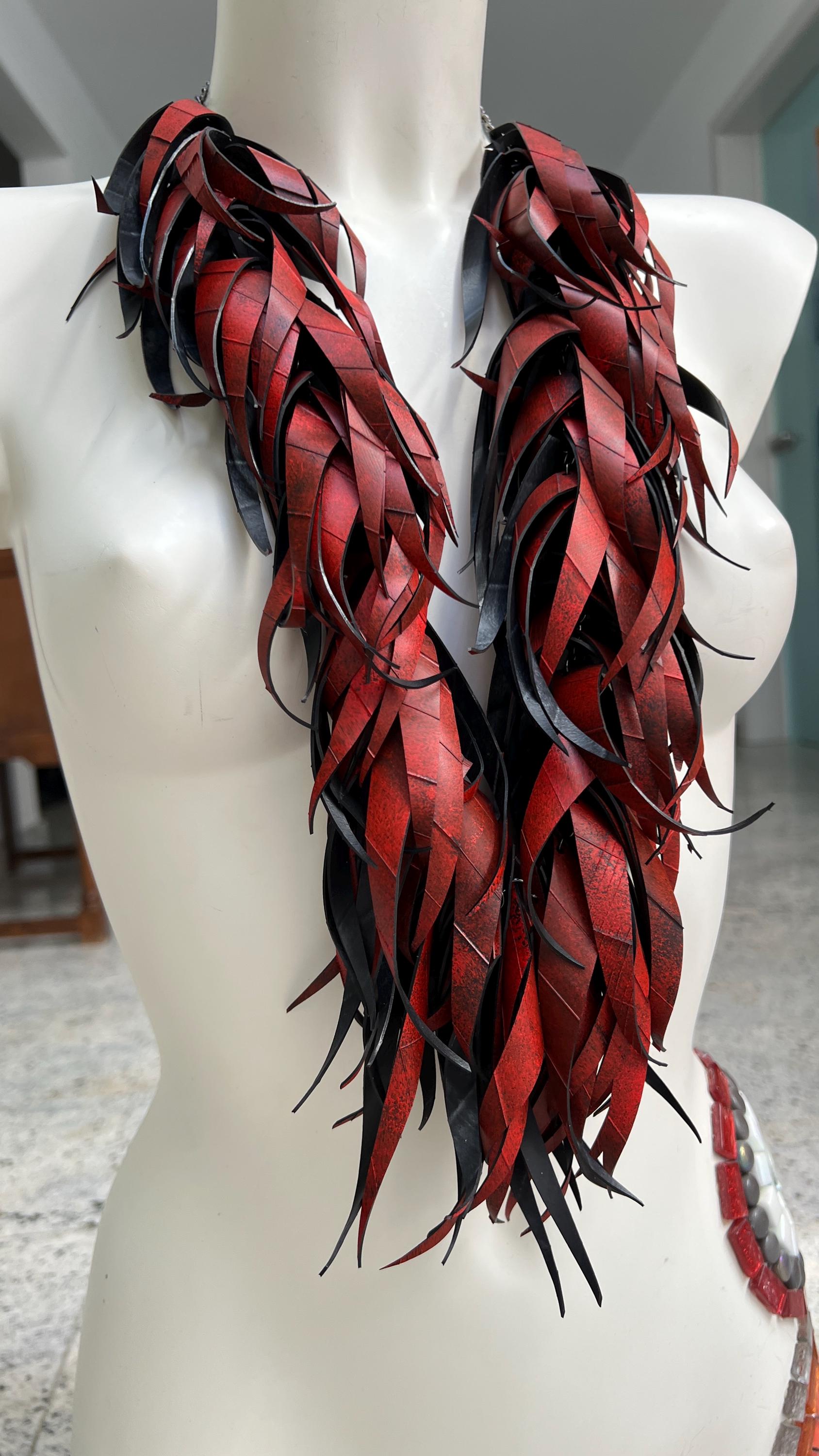 large, long red curly tassel neckace made from upcycled bicycle inner tube rubber on a white mannequin
