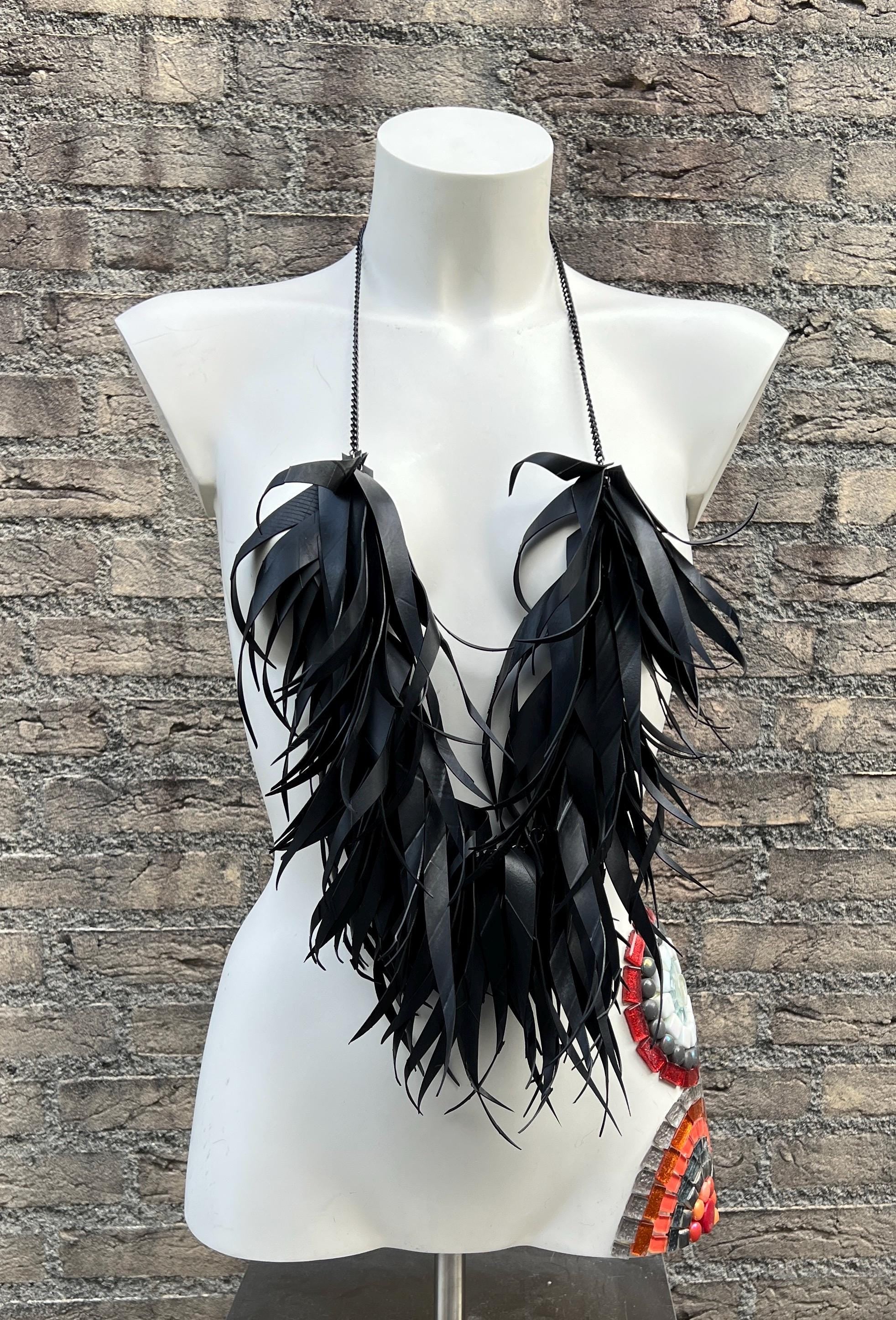 very large, oversized black curly tassel made from upcycled bicycle inner tube tassels on a white mannequin
