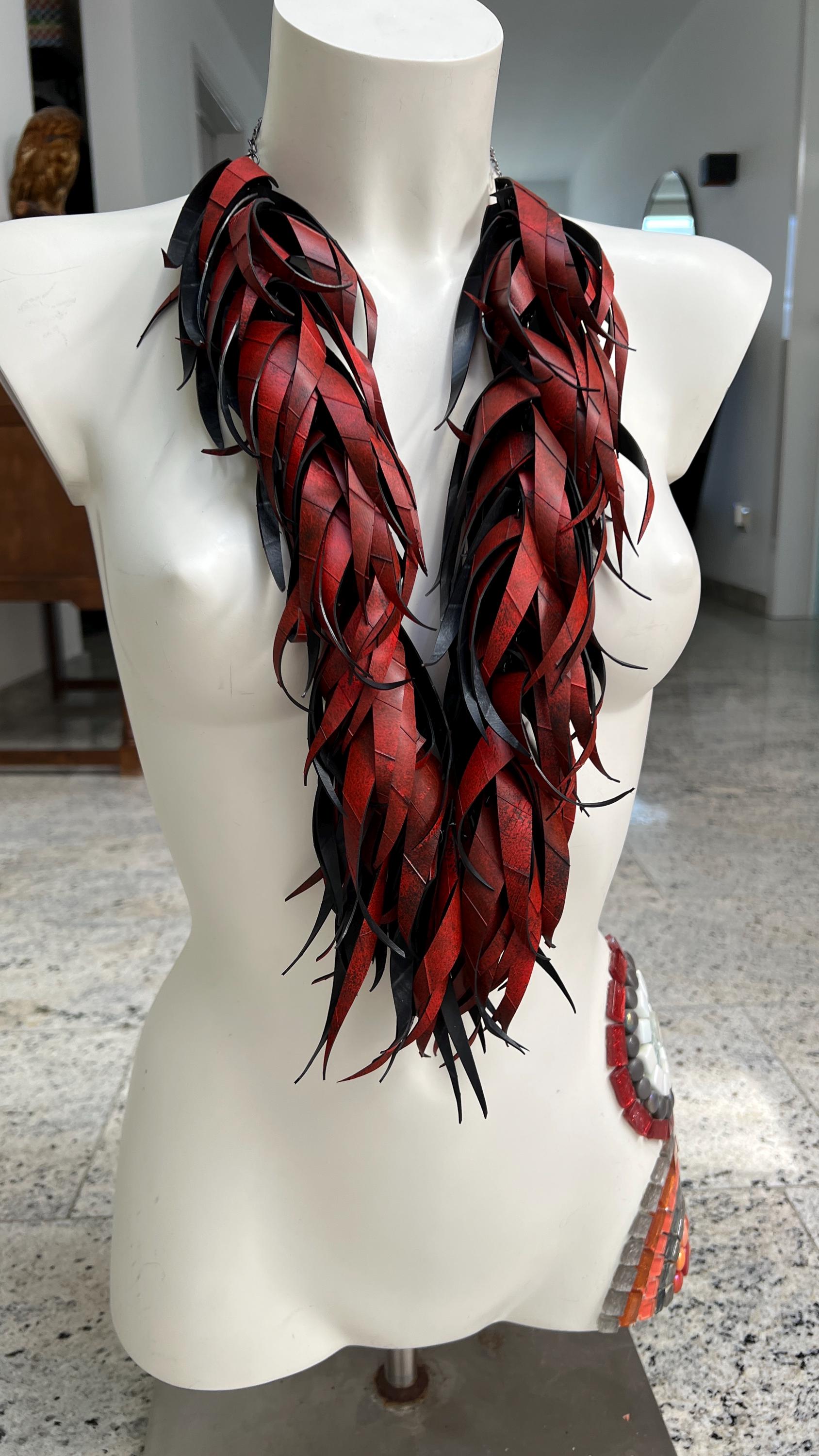 large, long red curly tassel neckace made from upcycled bicycle inner tube rubber on a white mannequin
