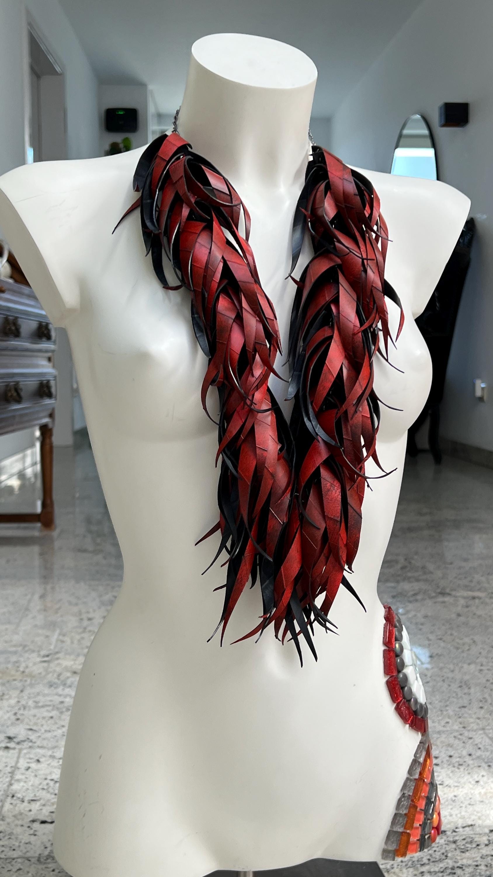 large, long red curly tassel neckace made from upcycled bicycle inner tube rubber on a white mannequin