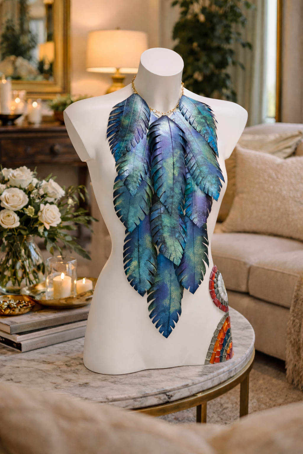 Mannequin wearing a blue-green leaf  shaped statement necklace made from upcycled bicycle inner tube in a home setting