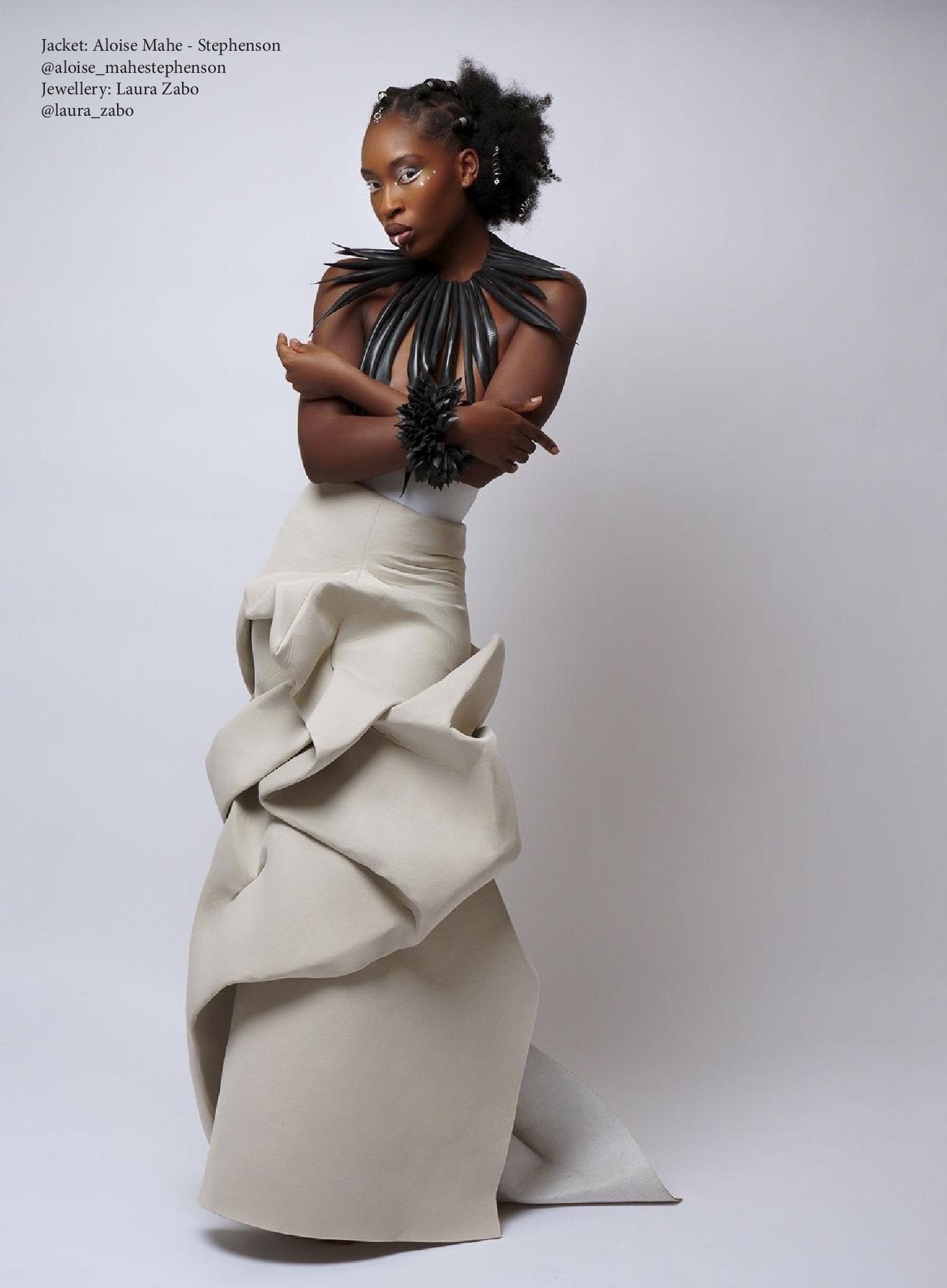 model wears a large black leather looking  collar, statement neckpiece made from upcycled bicycle inner tube rubber against a white wall
